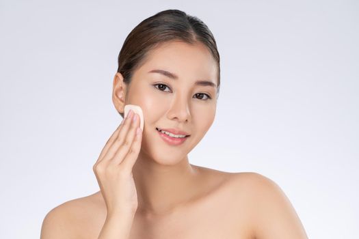 Gorgeous woman applying her cheek with dry powder. Portrait of younger with perfect makeup and healthy skin concept.