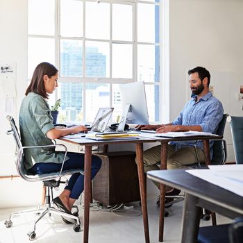 Entrepreneurs hard at work. colleagues working on their computers at a desk in an open plan office