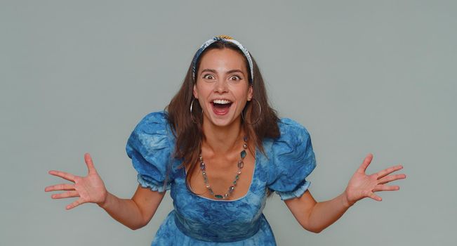 Oh my God, Wow. Excited amazed woman looking surprised at camera with big eyes, shocked by sudden victory game winning, lottery goal achievemen, good news. Adult girl on gray studio background indoor