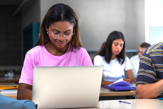 African american college student using laptop in class. Teen female black high school student doing homework. Copy space. Education concept.