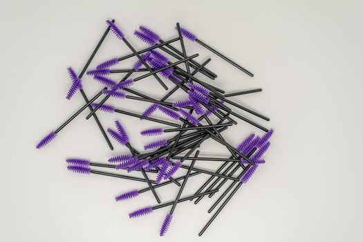 Purple makeup brushes, eyelash combs and eyebrows on white background with copy space.