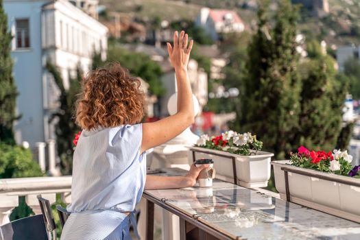 Happy beautiful woman drinking coffee with milk and having healthy breakfast in outdoor cafe in summer city in Europe