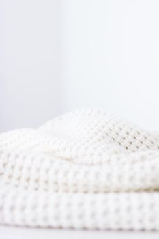 Knitwear, fabric textures and handmade items concept - Warm knitted clothes, soft and white