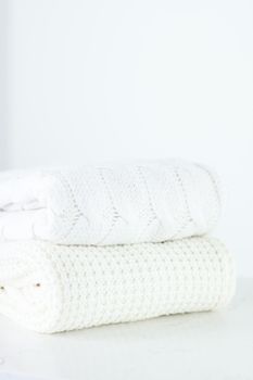 Knitwear, fabric textures and handmade items concept - Warm knitted clothes, soft and white