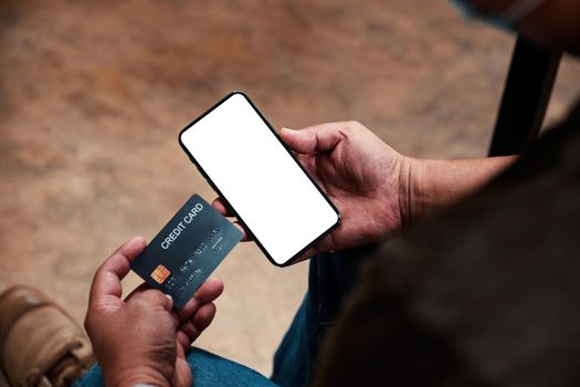 Hands holding smartphone blank screen and credit card