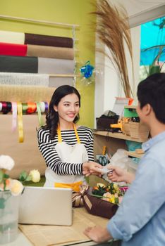 Young woman working as florist giving credit card to customer , Man giving credit card to the saleswoman