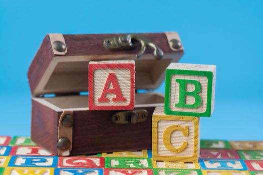 A, B, and C wooden block with treasure box in blue background