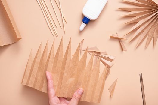 Cutting out the pointed parts of a palm leaf. Creative handwork to create tropical leaves. Master class.