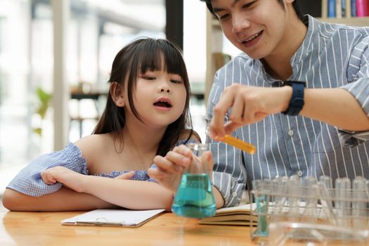 Girls and father doing science experiments. Education science concept.