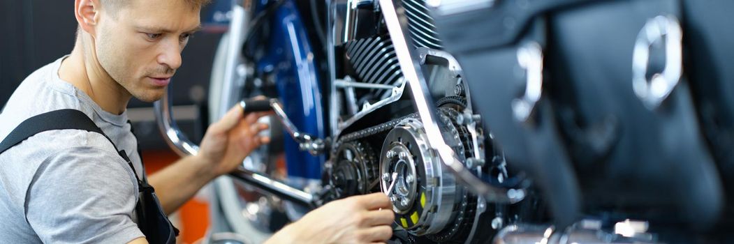 Master repairman repairing motorcycle in workshop with tools. Maintenance of cars and motorcycles concept