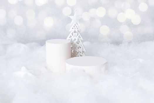 Podiums mok-up for cosmetics in the snow with a christmas tree on a bokeh background