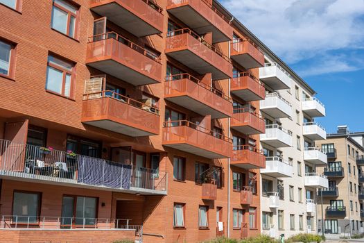 Red and white apartment buildings with many balconies seen in Berlin, Germany