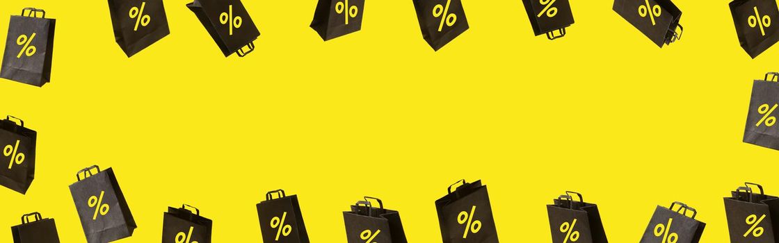 Banner with black sale shopping bags are flying on yellow background. Black Friday creative idea concept