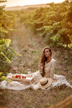 Young beautiful blonde woman on a picnic in the vineyards