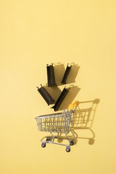 Flat lay miniature supermarket cart with shopping bags in black friday sale