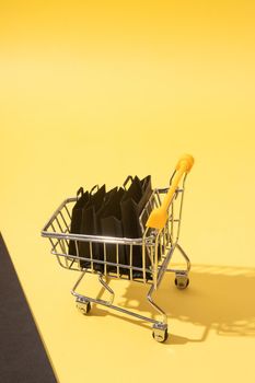 Miniature supermarket cart with shopping bags in black friday sale