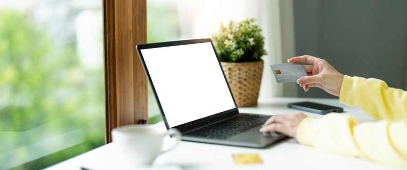 Online payment, Woman's hands holding credit card and using laptop computer for online shopping