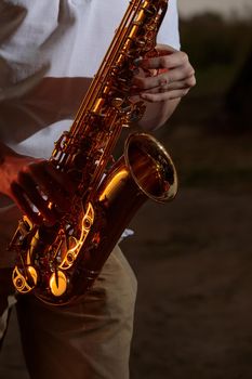 Hands and saxophone close up. The guy plays a wind instrument.