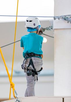 A boy climbs a suspension bridge in an entertainment complex