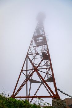 Radio repeater on top of a mountain in dense fog. Russia Ossetia.