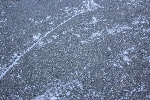 Asphalt with first snow. Illustration of frost and danger on the roads