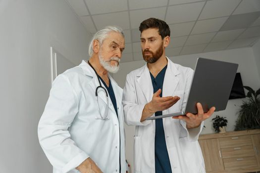 Two doctors are looking at something on the laptop in the doctor's office. High quality photo