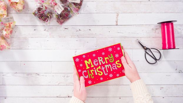 Flat lay. Step by step. Packaging homemade fudge and cookies into a Christmas gift box.