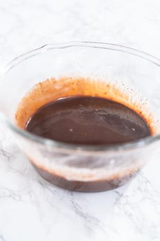 Preparing chocolate ganache in a glass mixing bowl.