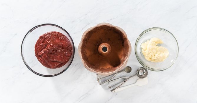 Flat lay. Filling metal bundt cake pan with cake butter to bake red velvet bundt cake with cream cheese glaze