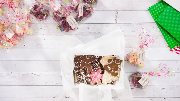 Flat lay. Step by step. Packaging homemade fudge and cookies into a Christmas gift box.