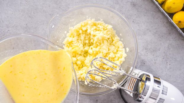 Flat lay. Step by step. Mixing ingredients in a glass mixing bowl to prepare lemon cranberry bundt cake.