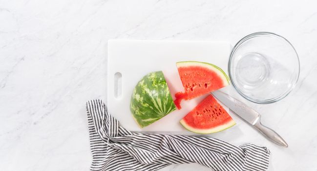 Flat lay. Cutting riped red watermelon to prepare frozen watermelon margarita.