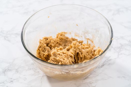 Mixing ingredients with a hand mixer to bake eggnog cookies with a chocolate gingerbread man.