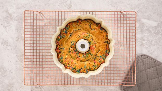 Flat lay. Step by step. Removing freshly baked funfettti bundt cake from the bundt cake pan.