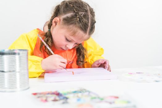 Little girl working on an art project with acrylic paint at homeschool.