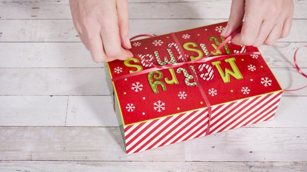 Step by step. Packaging homemade fudge and cookies into a Christmas gift box.