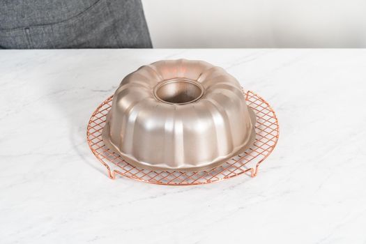 Cooling freshly baked red velvet bundt cake on a kitchen counter.