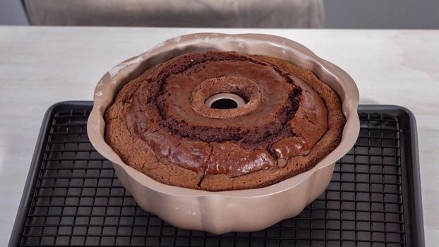 Step by step. Cooling freshly baked chocolate bundt cake on a cooling rack.