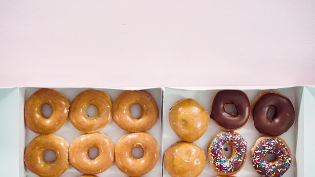 Flat lay. Variety of store-bought doughnuts in a white paper box.
