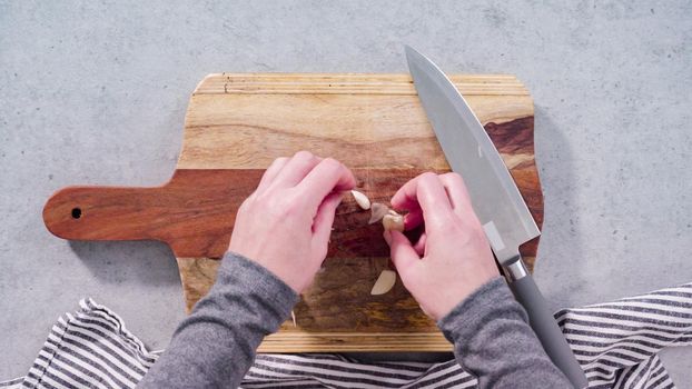 Cutting organic garlic on a wood cutting board.