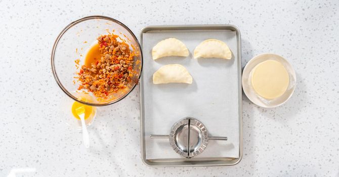 Flat lay. Filling empanada dough with turkey filling to make turkey empanadas.