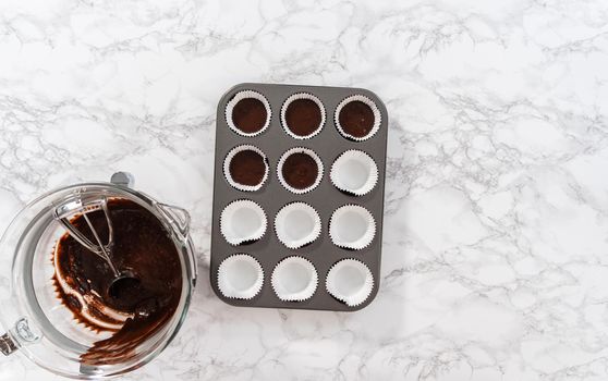 Flat lay. Baking chocolate cupcakes. Scooping chocolate cupcake batter into a cupcake pan.