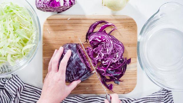 Flat lay. Step by step. Shredding organic cabbage on a wood cutting board.