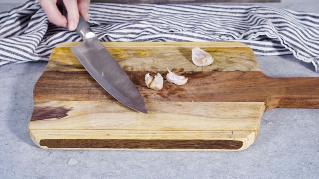 Cutting organic garlic on a wood cutting board.