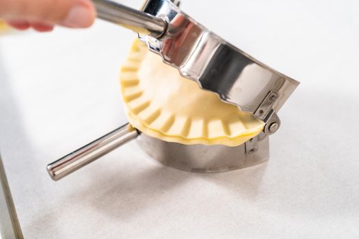 Flat lay. Filling empanada dough with turkey filling to make turkey empanadas.