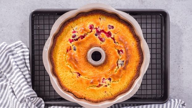 Flat lay. Step by step. Cooling lemon cranberry bundt cake on the kitchen wire rack.
