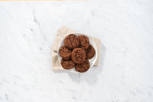 Flat lay. Freshly baked double chocolate chip cookies on a white plate.