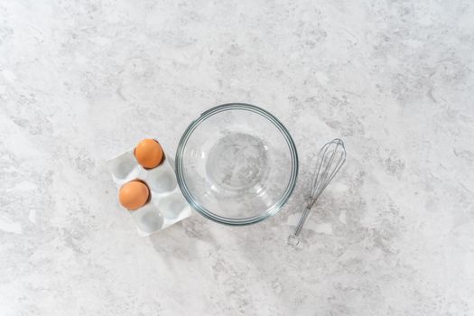 Flat lay. Mixing ingredients in a large glass mixing bowl to bake chocolate cookies with peppermint chips.