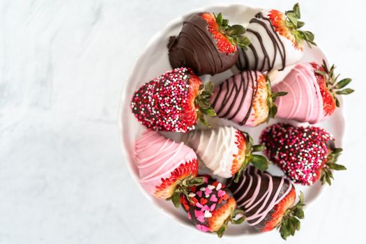 Variety of chocolate dipped strawberries on a cake stand.