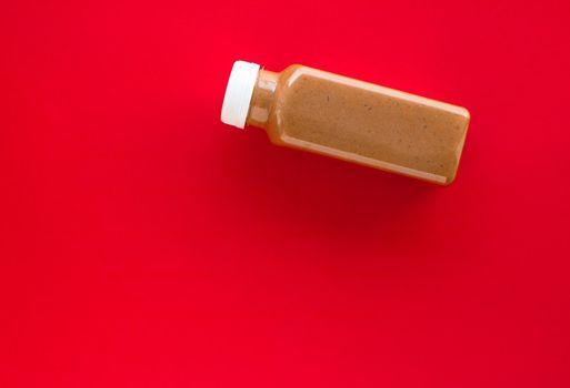 Detox, diet and healthy lifestyle concept - Chocolate banana smoothie bottle on red, flatlay